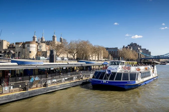Un barco de City Cruises amarrado en Tower Millennium Pier bajo la Torre de Londres en un día soleado
